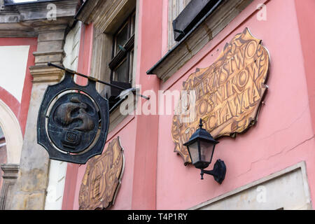 Ghisa placca e segni dipinti al di fuori di un molto vecchio pub, Wrocław, Wroclaw, Wroklaw, Polonia Foto Stock