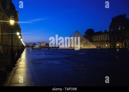 Museo del Louvre al crepuscolo in inverno. Il museo del Louvre è uno dei più grandi del mondo musei con più di 8 milioni di visitatori ogni anno. Foto Stock