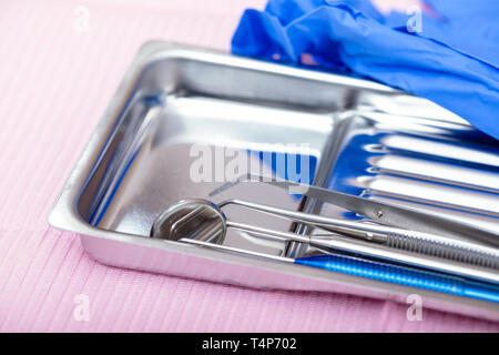 Close-up shot di sterilizzare gli strumenti dentali bocca specchio, sonda parodontale e forcipi sul vassoio di metallo pronto per essere utilizzato Foto Stock