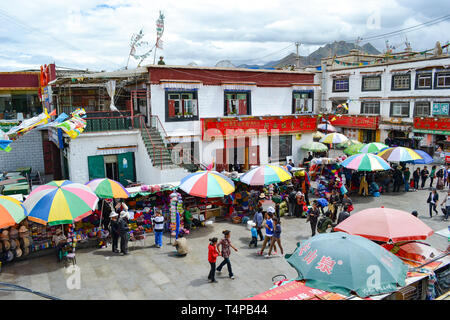 I pellegrini del buddismo tibetano, monaci, la gente del posto e i turisti a piedi attorno a Barkor, un popolare percorso devozionale intorno al tempio di Jokhang a Lhasa, in Tibet Foto Stock