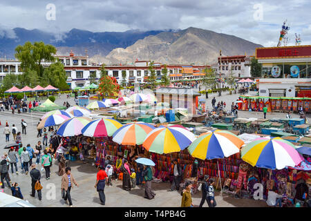 I pellegrini del buddismo tibetano, monaci, la gente del posto e i turisti a piedi attorno a Barkor, un popolare percorso devozionale intorno al tempio di Jokhang a Lhasa, in Tibet Foto Stock