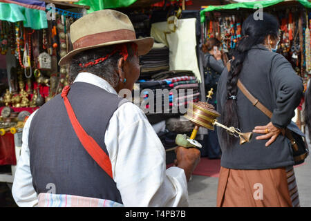 I pellegrini del buddismo tibetano, monaci, la gente del posto e i turisti a piedi attorno a Barkor, un popolare percorso devozionale intorno al tempio di Jokhang a Lhasa, in Tibet Foto Stock