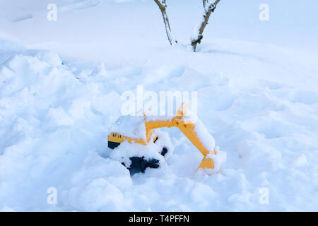 Giocattolo per bambini è lasciato da parte di bambini piccoli nella neve vicino alla casa Foto Stock