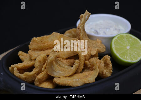 Deep alici fritte con salsa tartara e uno spicchio di lime in un piatto di portata Foto Stock