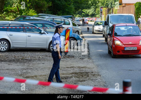 Rasnov, Romania, luglio 14, 2018: donna agente di polizia di guardia posto di parcheggio di fronte alla fortezza rasnov in Romania Foto Stock