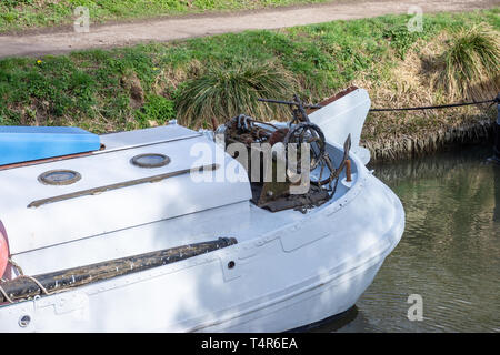 La poppa di un fiume in barca a vela con un vecchio arrugginito vintage verricello manuale ed il dispositivo di ancoraggio sul Kennet and Avon canal in Bradford on Avpn Wiltshire. Foto Stock