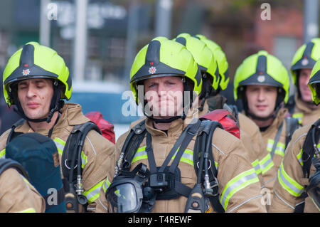 Glasgow, Scotland, Regno Unito. 18 Aprile, 2019. Sessanta partecipante vigili del fuoco piena di indossare un equipaggiamento protettivo personale su un sponsorizzato da marzo a raccogliere fondi per beneficenza a seguito di una heritage trail attraverso le strade della città. Il nuovo sono i vigili del fuoco in base alla scozzese del fuoco e di salvataggio Service National Training Center in Cambuslang, South Lanarkshire e sono undici settimane in formazione. Credito: Berretto Alamy/Live News Foto Stock