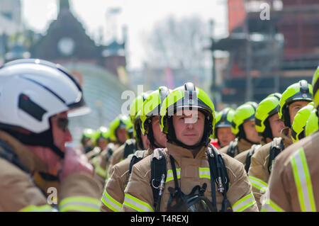 Glasgow, Scotland, Regno Unito. 18 Aprile, 2019. Sessanta partecipante vigili del fuoco piena di indossare un equipaggiamento protettivo personale su un sponsorizzato da marzo a raccogliere fondi per beneficenza a seguito di una heritage trail attraverso le strade della città. Il nuovo sono i vigili del fuoco in base alla scozzese del fuoco e di salvataggio Service National Training Center in Cambuslang, South Lanarkshire e sono undici settimane in formazione. Credito: Berretto Alamy/Live News Foto Stock