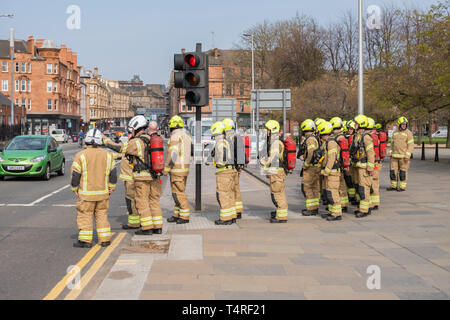 Glasgow, Scotland, Regno Unito. 18 Aprile, 2019. Sessanta partecipante vigili del fuoco piena di indossare un equipaggiamento protettivo personale su un sponsorizzato da marzo a raccogliere fondi per beneficenza a seguito di una heritage trail attraverso le strade della città. Il nuovo sono i vigili del fuoco in base alla scozzese del fuoco e di salvataggio Service National Training Center in Cambuslang, South Lanarkshire e sono undici settimane in formazione. Credito: Berretto Alamy/Live News Foto Stock