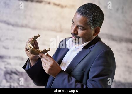 Mauer, Germania. Xvii Apr, 2019. John Ehret, sindaco del comune di Mauer, osserva la replica di una mandibola di Homo Heidelbergensis trovati in Mauer in Grafenrain buca di sabbia nel municipio. Questa ganascia ha un enorme significato per la storia dell'umanità. I fossili trovati in un luogo secco Neckar bow appartiene con i suoi 610 000 anni per i più antichi reperti umani in Europa. (A dpa 'Homo Heidelbergensis - La comunità che i sogni di un museo') Credito: Uwe Anspach/dpa/Alamy Live News Foto Stock