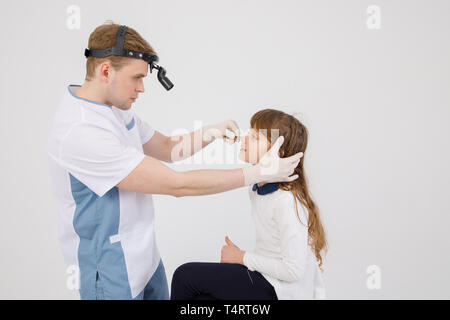 Otolaryngologist esamina l uomo del naso con dilatatore nasale. Attrezzature mediche. Foto Stock