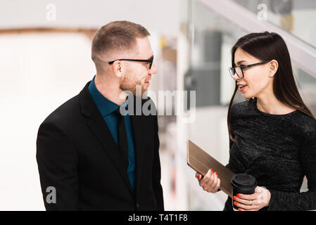 Imprenditore e imprenditrice discutendo di qualcosa durante la pausa caffè. Foto Stock