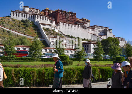 I pellegrini del Buddismo tibetano a piedi nella parte anteriore del palazzo del Potala a Lhasa, in Tibet Foto Stock