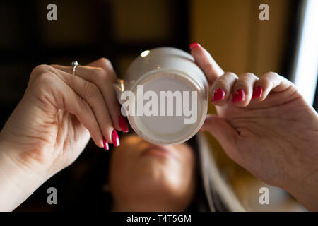 La ragazza beve caffè in un bar. Vista dal basso Foto Stock