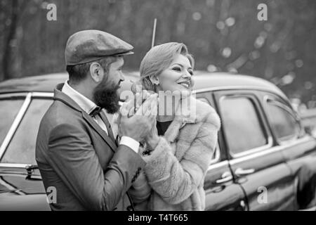 Elegante amorevole sposi abbracciando in un bosco vicino a auto rétro Foto Stock