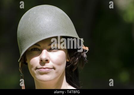 Donna felice con casco militare Foto Stock