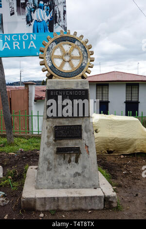 Kasani, Bolivia - 28. Maggio 2017: Frontiera tra Bolivia e Perù, grigio pietra di confine con segni e un golden-ruota blu sulla parte superiore Foto Stock