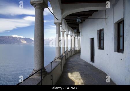Eremo di Santa Caterina del Sasso sul Lago Maggiore con Snow-capped Mountain a Leggiuno in Lombardia, Italia. Foto Stock
