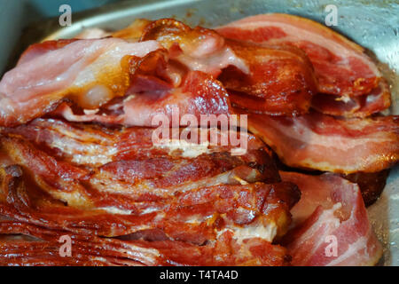 Deliziosa cotta bacon croccante fette di pancetta di maiale grasso e pelle croccante di colore stupendo close up alimenti dannosi per la salute Foto Stock