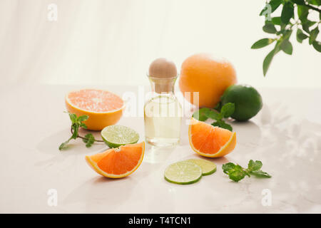 Organici cosmetici con estratti di erbe di limone, arancio, menta su sfondo lucido Foto Stock