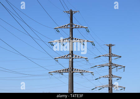 Linea di alimentazione supporti con fili elettrici sul cielo blu chiaro dello sfondo. La trasmissione di energia elettrica ad alta tensione, le linee di alimentazione di potenza concept Foto Stock