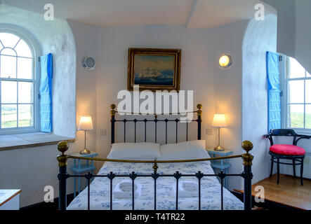 Letto singolo quadrato con morbidi cuscini contro la testiera in metallo  nero all'interno della camera da letto Foto stock - Alamy