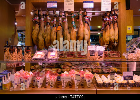 Le bancarelle che vendono jamón serrano, il dry-cured prosciutto spagnolo fatta con i suini di razza iberica, a Barcellona, Spagna Foto Stock