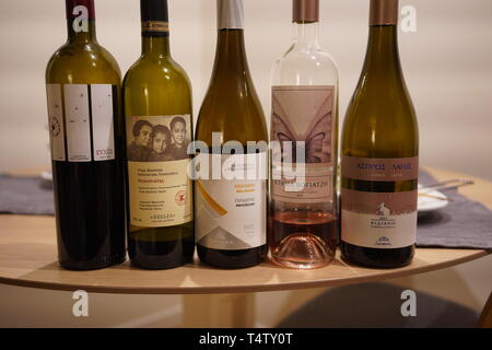 Filiera di cinque vini greci, rossi, bianchi e rosati, allineati su un tavolo a una festa, Madrid, Spagna Foto Stock