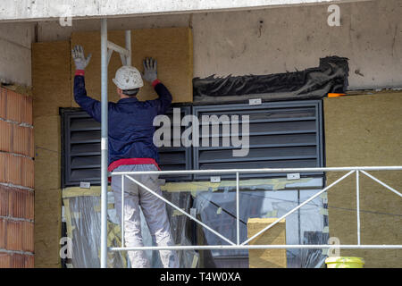 Edificio esterno a parete di isolamento termico. Builder installazione di lana di roccia e la lana minerale board con colla. Foto Stock