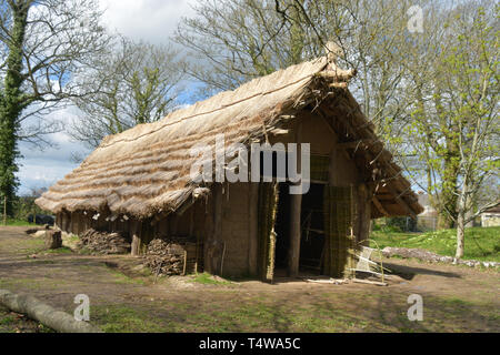 Il neolitico Longhouse presso La Hougue Bie museo è stato costruito utilizzando strumenti antichi e mestieri.Con una lamella tetto di paglia supportato su colonne di legno. Foto Stock