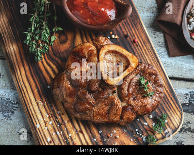 Cucinato osso buco Stinco di vitello su una porzione del bordo closeup Foto Stock