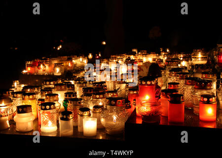 Mazzetto di cimitero candele in un buio Foto Stock