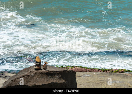 2019, gennaio. Florianópolis, Brasile. Le pietre piccole sculture che assomigliano a due persone di fronte al mare, su una zona rocciosa. Foto Stock