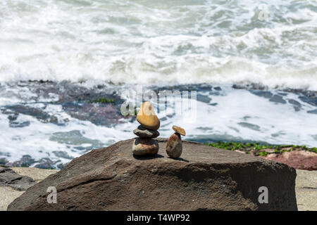 2019, gennaio. Florianópolis, Brasile. Le pietre piccole sculture che assomigliano a due persone di fronte al mare, su una zona rocciosa. Foto Stock