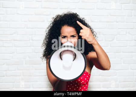 Ritratto di arrabbiato americano africano donna gridando con megafono per protesta. Nero Ragazza mostra rage, la rabbia e la ribellione dei diritti umani, sciopero, p Foto Stock