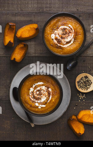 Due ciotole di arrosto zuppa di zucca su un tavolo rustico Foto Stock