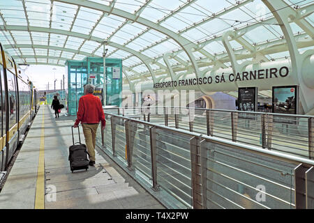 L'uomo con i bagagli in passerella coperta che conduce alla metropolitana e ferroviaria di collegamenti di trasporto in aeroporto Francisco Sa Carneiro in Porto Portogallo UE KATHY DEWITT Foto Stock