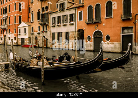 Due gondole in dock lungo un piccolo canale a Venezia in Italia. Foto Stock