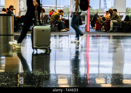 Immagini sfocate di viaggiatori a piedi in aeroporto e persone in area di attesa Foto Stock