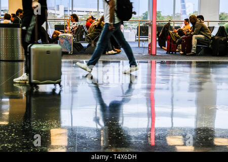 Immagini sfocate di viaggiatori a piedi in aeroporto e persone in area di attesa Foto Stock