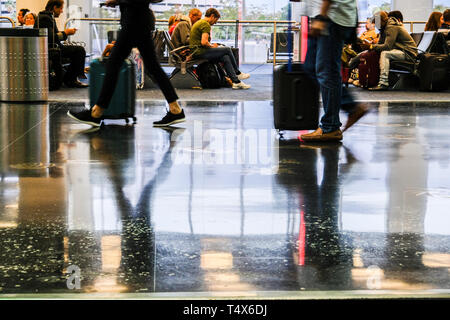 Immagini sfocate di viaggiatori a piedi in aeroporto e persone in area di attesa Foto Stock