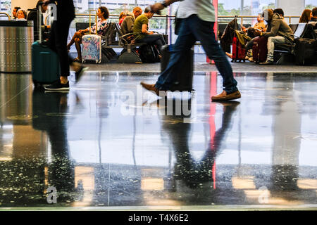 Immagini sfocate di viaggiatori a piedi in aeroporto e persone in area di attesa Foto Stock