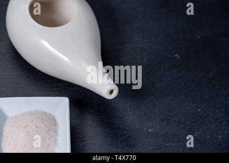 Set per pulizia nasale con neti pot, medicina ayurvedica sistema su un nero ardesia, vista dall'alto, con sale hymalaian Foto Stock