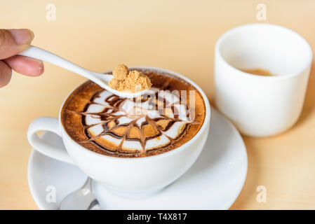 Aggiungere lo zucchero di caffè caldo Foto Stock