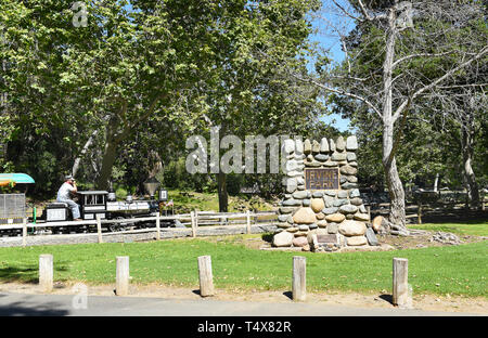 Arancione, CALIFORNIA - 18 Aprile 2019: l'Irvine Railroad miniatura treno passa dalla dedizione marcatore in Irvine Parco Regionale. Foto Stock