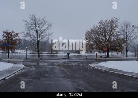 Un ciclista invernale passeggiate lungo il ciclo di congelati percorso, Dow's Lake, Ottawa, Ontario, Canada. Foto Stock