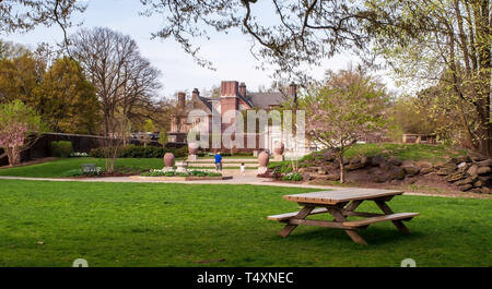 Mellon Park campo con un banco di picnic e un uomo con una piccola ragazza camminare verso il giardino del Parco in primavera a Pittsburgh, PA, Stati Uniti d'America Foto Stock