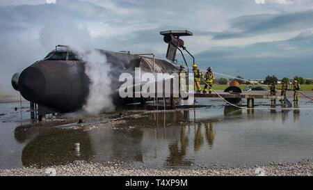 Vigili del fuoco spruzzare acqua su una simulazione di aerei per raffreddarlo dopo il live-formazione antincendio a Sheppard Air Force Base in Texas, 17 aprile 2019. Gli equipaggi da Sheppard, Wichita Falls, Texas, e Lawton, Oklahoma, fatta convergere sulla fossa di formazione per approfondire le loro competenze a attaccare gli incendi di aeromobili esternamente e internamente. Sheppard, situato sul bordo del nord di Wichita Falls, è la casa del 80th Flying ala formazione di Euro-NATO Joint Jet pilota del programma di formazione che utilizza la gamma di artiglieria a Fort davanzale vicino Lawton. (U.S. Air Force foto da John Ingle) Foto Stock