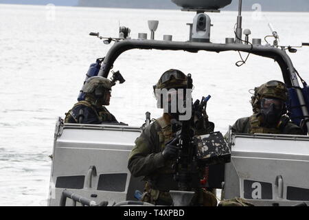 La sicurezza marittima la risposta del team di West i membri sono pronti a rispondere in un pieno esercizio della scala, chiamati operazione di pesca pelagica sciopero, per il treno in un multiagency simulato situazione terrorista a bordo di un traghetto a Cordova, Alaska, 10 aprile 2019. MSRT West personale addestrato con Alaska della FBI terrorismo Joint Task Force per garantire che se una minaccia sono stati riscontrati in Alaska che i sistemi erano in posizione per mantenere la sicurezza pubblica. Stati Uniti Coast Guard foto di Chief Petty Officer Matthew Schofield. Foto Stock