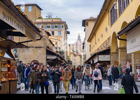 La gente che camminava sul Ponte Vecchio, un medievale ponte in pietra con negozi su di esso, Firenze, Italia Foto Stock